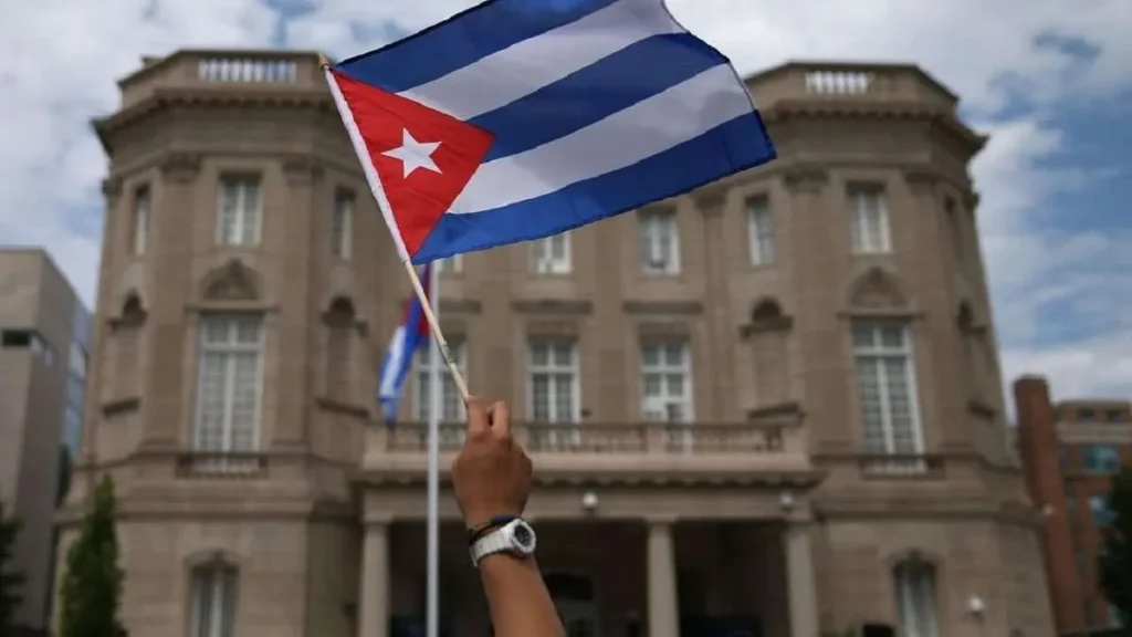 Mão segura bandeira de Cuba em frente a edifício, possivelmente em Washington. (Foto: ultimasnoticias.com.ve)