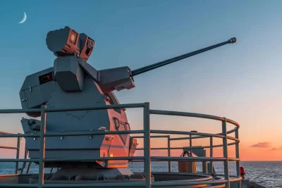 Sistema de arma remota instalado em navio militar ao entardecer. (Foto: navalnews.com)