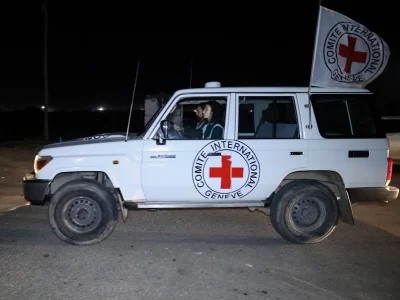Veículo do Comitê Internacional da Cruz Vermelha com bandeira hasteada, em operação noturna. (Foto: aljazeera.com)