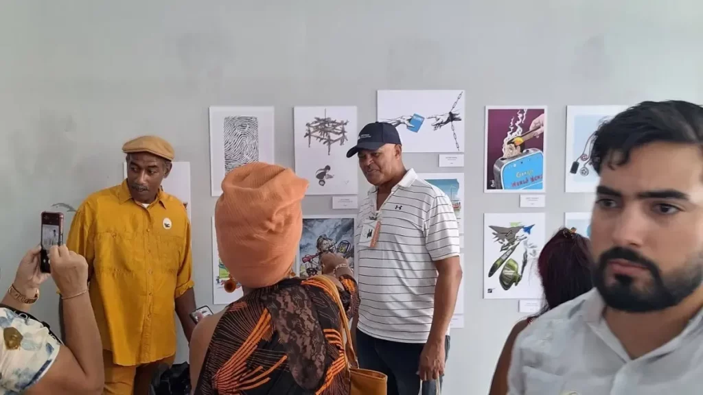 Visitantes observam obras expostas na Bienal de Humor Político em Cuba. (Foto: telesurtv.net)
