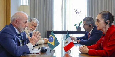 Presidente Lula participa de reunião com autoridades mexicanas, com bandeiras do Brasil e México à mesa. (Foto: agenciabrasil