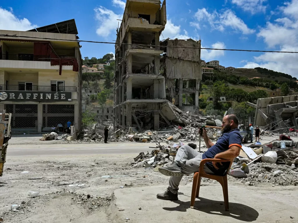 Homem observa a destruição de edifícios em meio a escombros no sul do Líbano. (Foto: aljazeera.com)