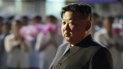 Kim Jong-un em evento público, com pessoas ao fundo segurando flores. (Foto: actualidad.rt.com)