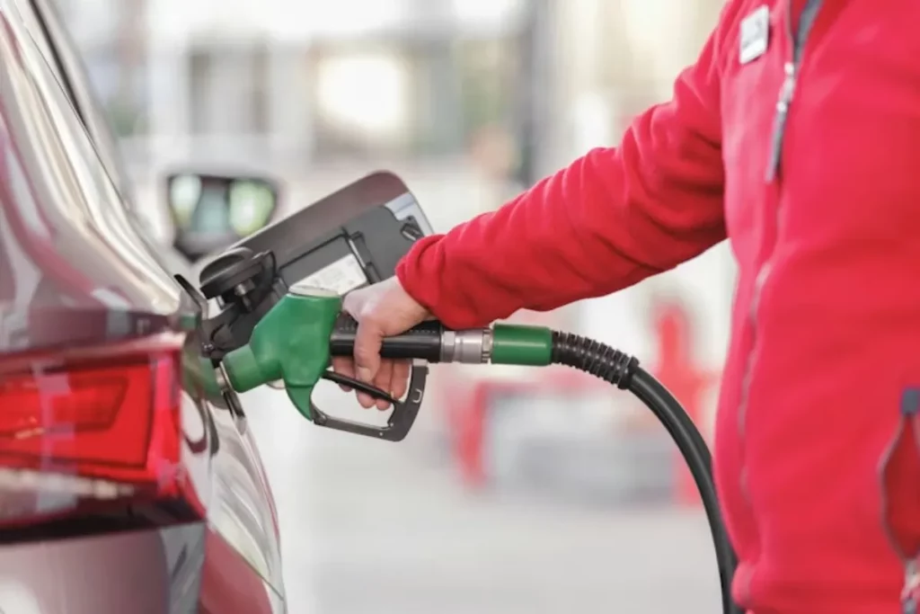 Pessoa abastecendo um carro com combustível em posto de gasolina.