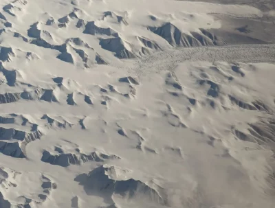 Vista aérea de geleiras cobrindo montanhas nevadas na Antártida. (Foto: Wikimedia Commons)