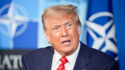 O presidente Donald Trump durante evento com bandeiras da OTAN ao fundo. (Foto: actualidad.rt.com)