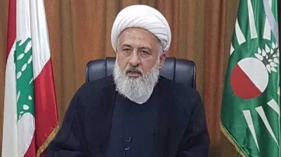Sheikh Ali al-Khatib, com as bandeiras do Líbano e de um partido político ao fundo. (Foto: en.mehrnews.com)