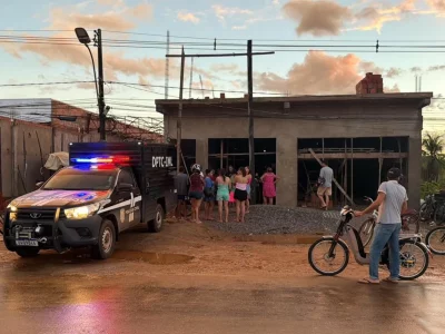 Veículo da Polícia Civil do Acre em frente a edifício com grupo de pessoas observando, em área residencial. (Foto: g1.globo.c