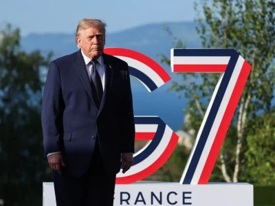 Presidente Donald Trump posa em frente ao símbolo do G7 durante evento na França. (Foto: aljazeera.com)